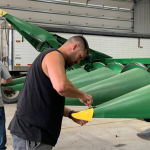 Millennial Farmer Zach Johnson installing May Wes Snoot Boot on John Deere C Series Corn Head